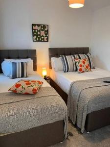 1 dormitorio con 2 camas con almohadas en Stay at The Penn! 5 Bedroomed home in Treharris, en Treharris