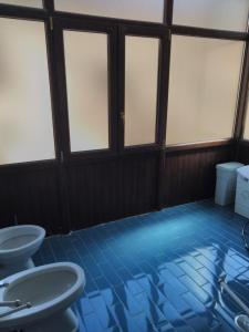 RotondiにあるCasa vacanza al borgoの青いタイルフロアのバスルーム(4つの窓付)