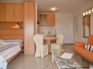 a room with a bed and a kitchen with a table at Apartments Villa Slavica in Ičići