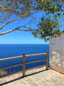 un banco de madera sentado junto al océano en Villa Parque Mirador en Playa de Santiago