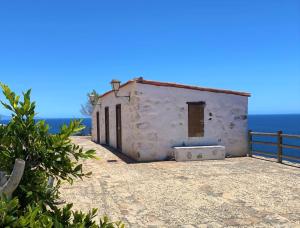 a small white building on the side of the ocean at Villas Parque Mirador in Playa de Santiago