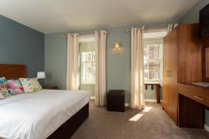 a bedroom with a large bed and a window at Queens Head Hotel in Berwick-Upon-Tweed