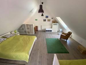 Un dormitorio con una cama verde y una escalera en HUTA-TÚRA 42 Vendégház, en Háromhuta