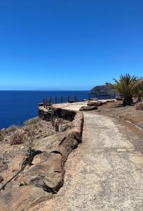 プラヤ・デ・サンティアゴにあるVilla Parque Miradorの晴れた日の海の横の未舗装道路