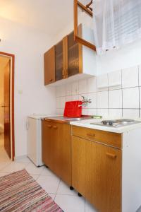 a kitchen with a sink and a refrigerator at Apartments by the sea Poljica, Trogir - 10353 in Marina