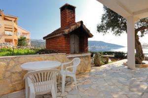 a patio with a table and chairs and a brick oven at Apartments by the sea Poljica, Trogir - 10353 in Marina