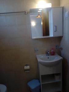 a bathroom with a sink and a mirror at La Cite Family Hotel & Apartments in Moraitika