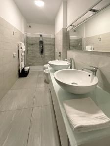 - Baño blanco con 2 lavabos y ducha en B&B Villa Paradiso en Urbino