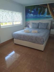 a bedroom with a bed with a painting on the wall at Refúgio Singelo in Espinho