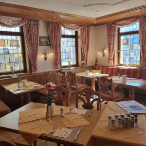 un ristorante con tavoli e sedie in legno e finestre di Hotel & Restaurant Krone a Geislingen an der Steige