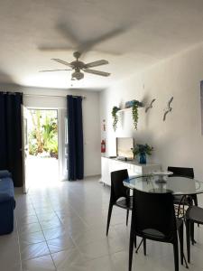 a living room with a ceiling fan and a table and chairs at Vilabranco in Albufeira