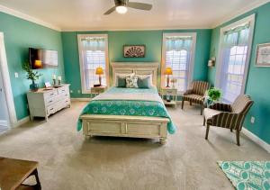 a bedroom with a bed and green walls and windows at Barren Breeze Bed and Breakfast in Lucas