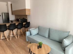 uma sala de estar com um sofá azul e uma mesa em Rakowicka Modern Apartment na Cracóvia