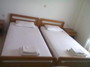 two beds in a small room with plates and utensils at La Cite Family Hotel & Apartments in Moraitika