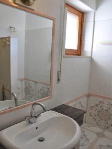 a white bathroom with a sink and a mirror at Hotel L'Oasi in Cala Gonone