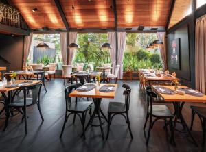 - un restaurant avec des tables, des chaises et de grandes fenêtres dans l'établissement Bavaria Sport Hotel, à Gramado
