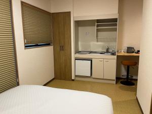 a room with a bed and a small kitchen at YADO TENKU Kyoto Nijo in Kyoto
