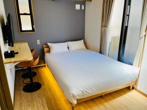 a small bedroom with a bed and a desk at YADO TENKU Kyoto Nijo in Kyoto