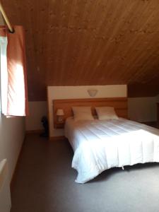 a bedroom with a large bed with a wooden ceiling at Chalet sur bord de l'eau in Nontron