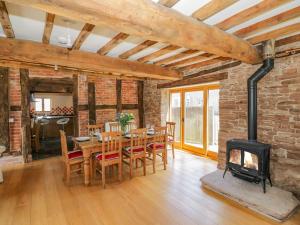 a dining room with a table and a fireplace at Munderfield Mill in Bromyard
