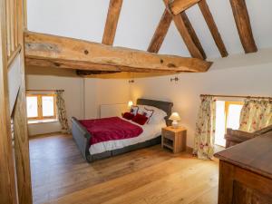 a bedroom with a bed in a room with wooden floors at Munderfield Mill in Bromyard