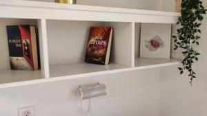 a shelf with books on it with a lightswitch at Calma bungalows in Portorož