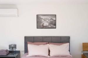 um quarto com uma cama com almofadas cor-de-rosa e brancas em OZ - Obecana Zemlja Permaculture Homestead em Blagaj