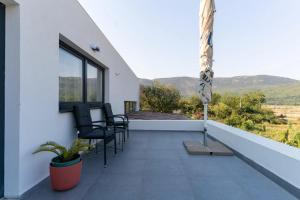 einen Balkon mit Stühlen und Bergblick in der Unterkunft OZ - Obecana Zemlja Permaculture Homestead in Blagaj