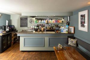 a bar in a room with a counter with alcohol at Queens Head Hotel in Berwick-Upon-Tweed