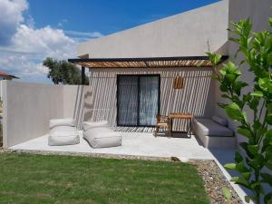 a patio with two couches and a table at Pure Villas in Ormos Panagias