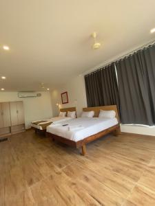 een slaapkamer met een groot bed en een groot raam bij Hotel Bluestone in Srikalahasti