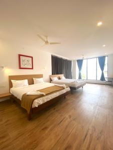 a bedroom with a large bed and a ceiling fan at Hotel Bluestone in Srikalahasti