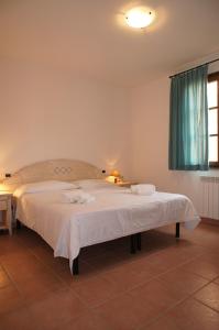 a bedroom with a large bed with towels on it at Appartamenti in Residence Villa Santa Maria in San Vincenzo