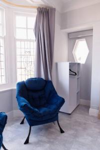 a blue chair in a room with a window at Lovely, Cosy Beachside Cottage 1 - Perfect Location in Llandudno