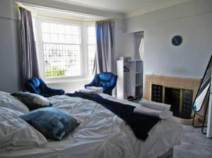 a bedroom with a large bed with blue chairs at Lovely, Cosy Beachside Cottage 1 - Perfect Location in Llandudno