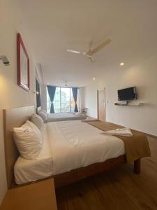 a bedroom with a large bed with a ceiling fan at Hotel Bluestone in Srikalahasti