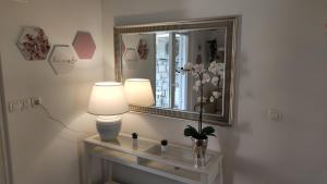 a room with a mirror and a table with a lamp at Calma bungalows in Portorož