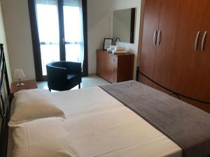 una camera con un grande letto e una sedia di Appartamenti Angelica 2 a Pisa