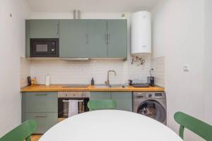 een keuken met groene kasten en een wasmachine bij Ola Lisbon - Alfama III in Lissabon