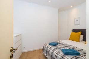 een slaapkamer met een bed met blauwe kussens erop bij Ola Lisbon - Alfama III in Lissabon