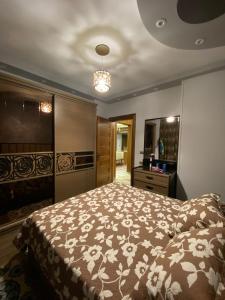 um quarto com uma cama grande e uma televisão em جاردينيا سيتي الماظه no Cairo