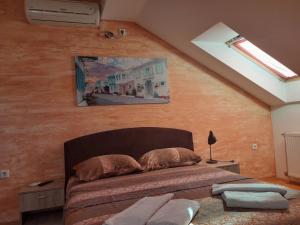 1 dormitorio con 1 cama y una pintura en la pared en Apartment Loft en Čačak
