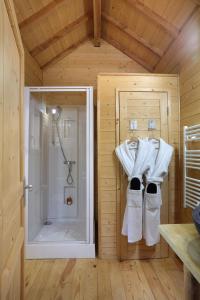 a bathroom with a shower and towels on a wall at Les Lodges de Babylone in Larringes