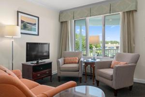a living room with a couch and chairs and a tv at The Sparhawk Oceanfront Resort in Ogunquit