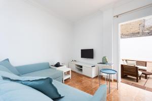 a living room with a blue couch and a tv at Estudio con gran terraza Chill Out in Guía de Isora