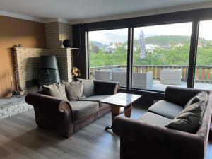 sala de estar con 2 sofás y chimenea en Feriehus i Flekkefjord med panoramautsikt en Flekkefjord