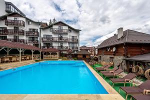 a hotel with a swimming pool in front of a building at Марина in Bukovel
