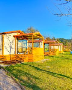 una grande casa gialla su un prato di Coimbra Camping & Bungalows a Coimbra
