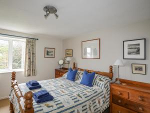 une chambre avec un lit avec des oreillers bleus dessus dans l'établissement Llwyn Gwalch, à Pwllheli