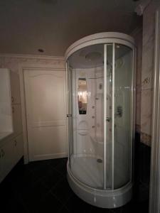 a glass shower in a bathroom with a door at Feriehus i Flekkefjord med panoramautsikt in Flekkefjord